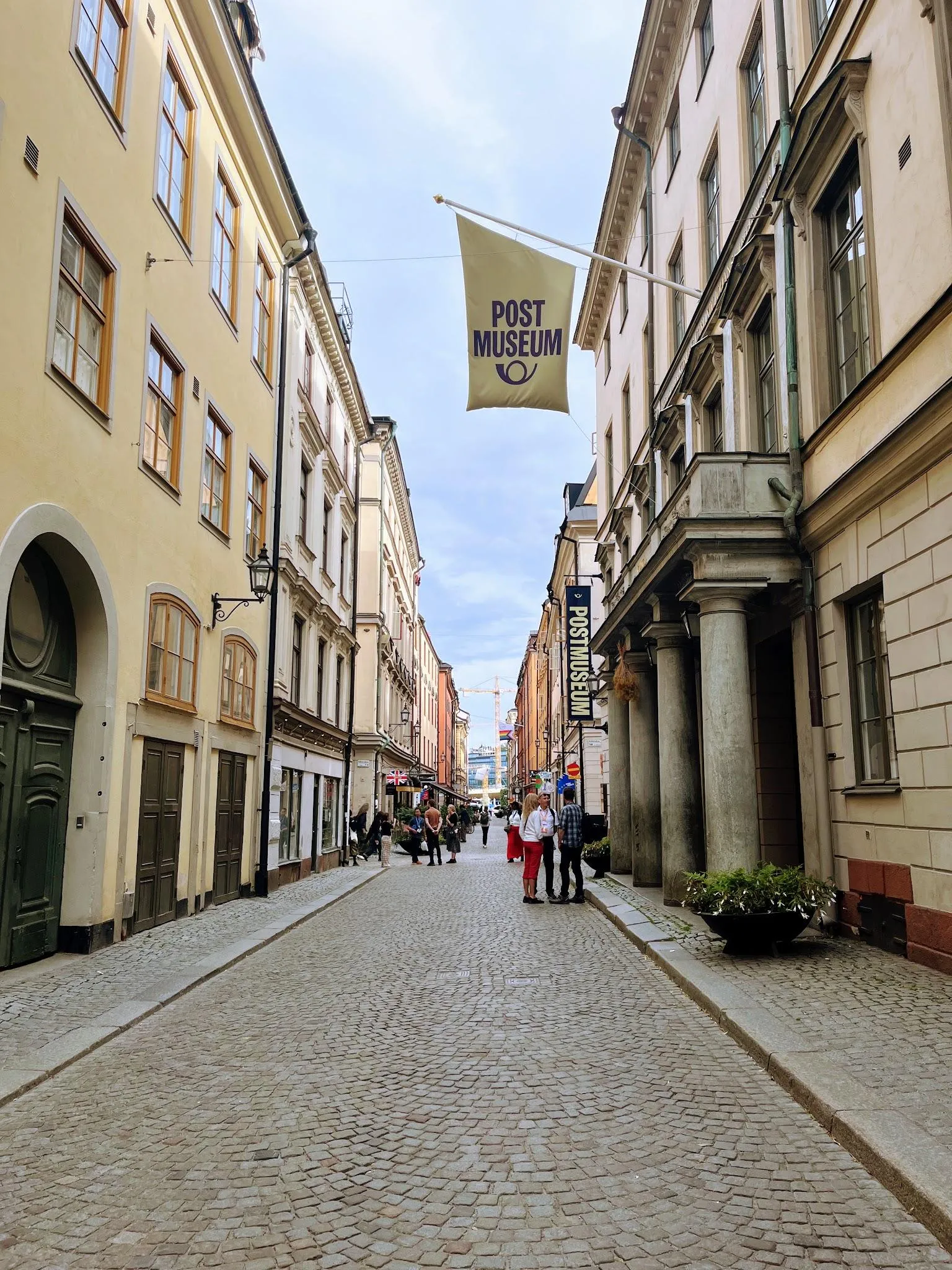Lilla Nygatan in Gamla stan: a cobbled car-free street with people strolling between old town facades.