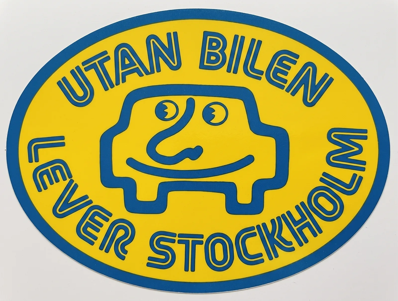 Klistermärke i gult och blått med en glad tecknad bil och texten Utan bilen lever Stockholm.